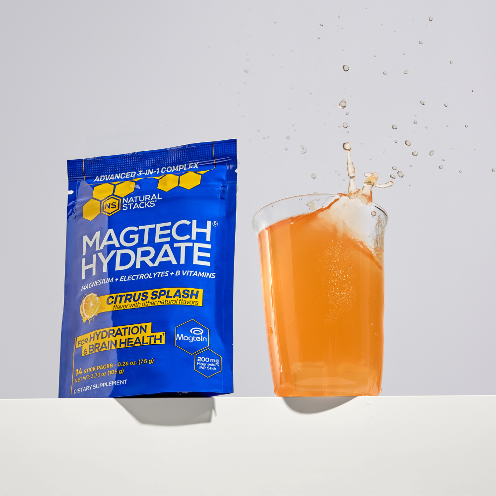 MAGTECH HYDRATE supplement packet with a glass of orange juice on a light gray background