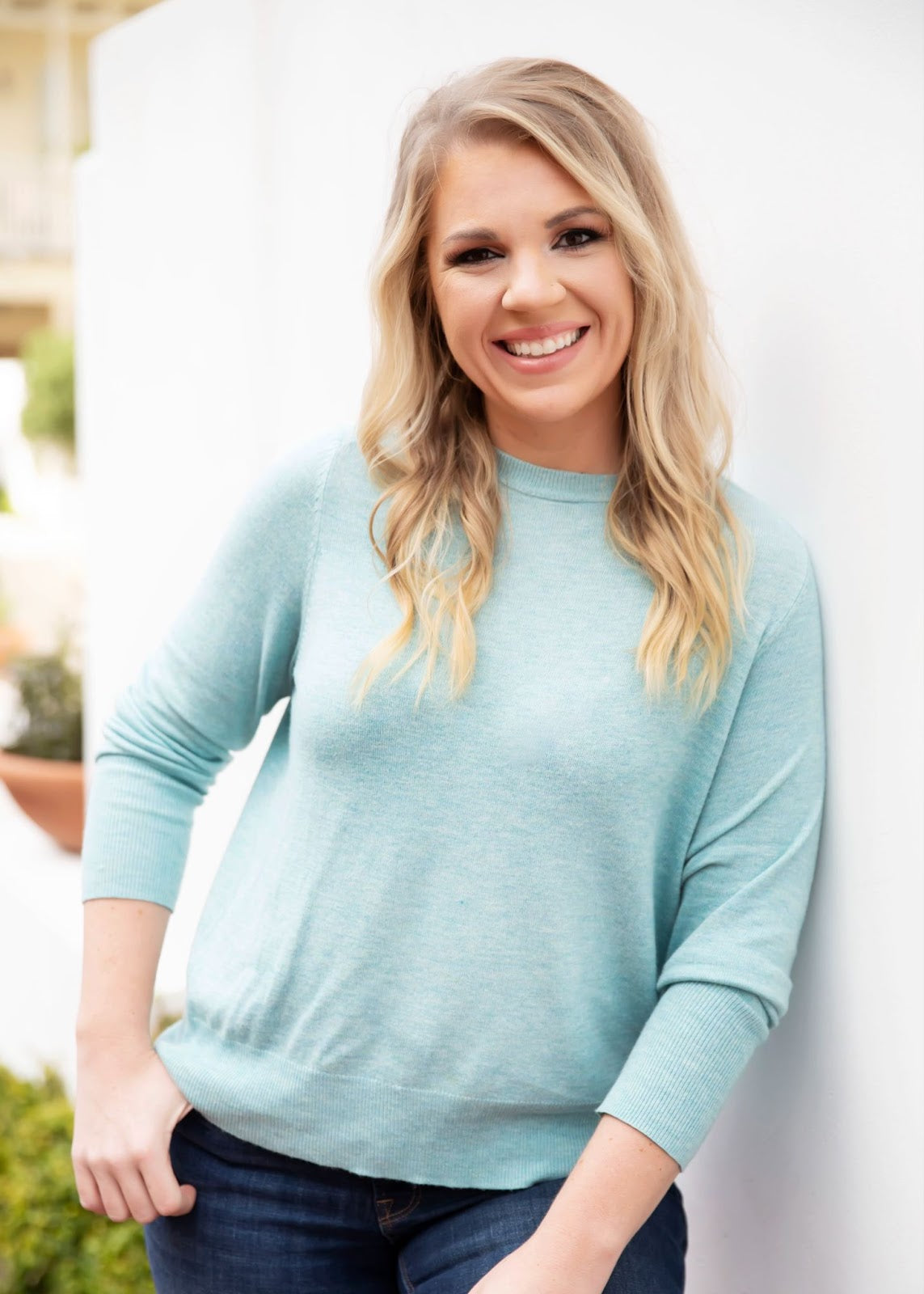 woman leaning against wall smiling