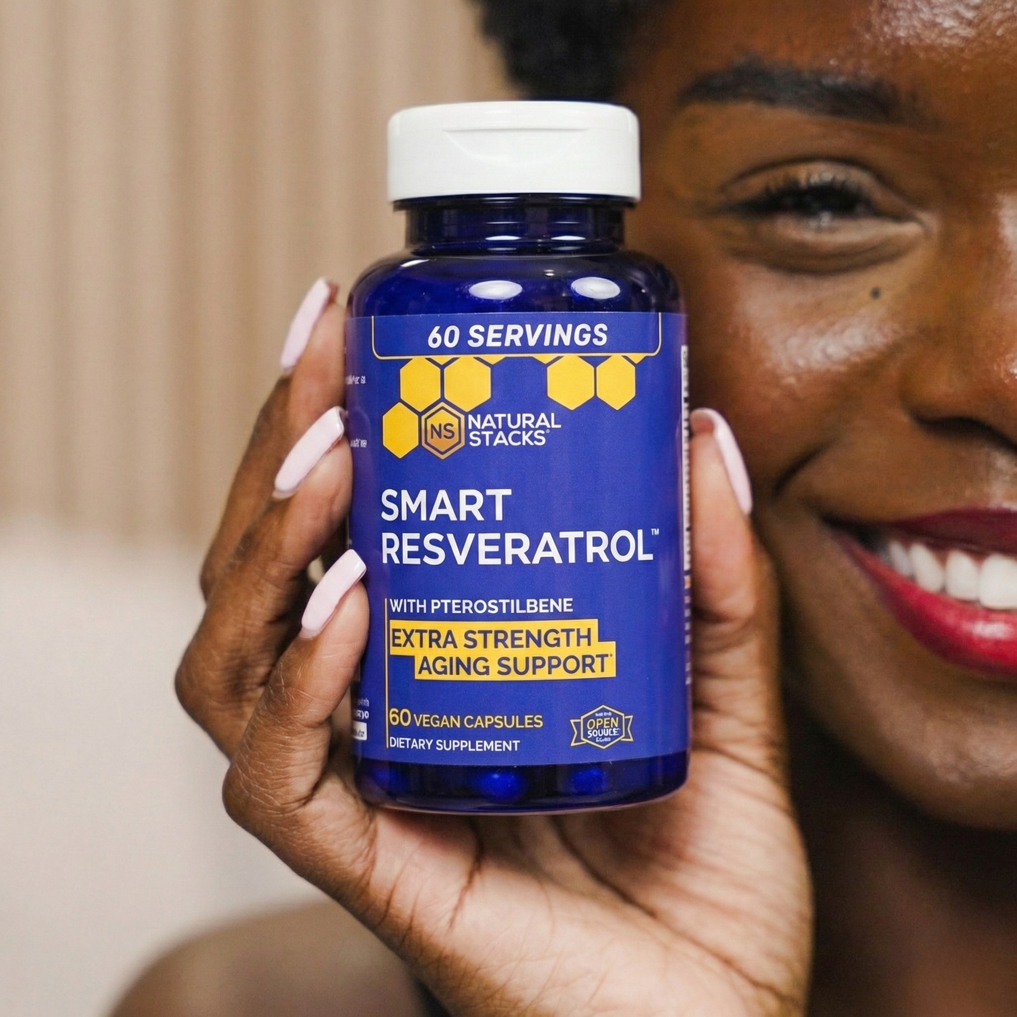 Person holding a bottle of Smart Resveratrol supplement with a blurred background